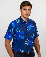 Man wearing a blue floral patterned golf shirt against a white background