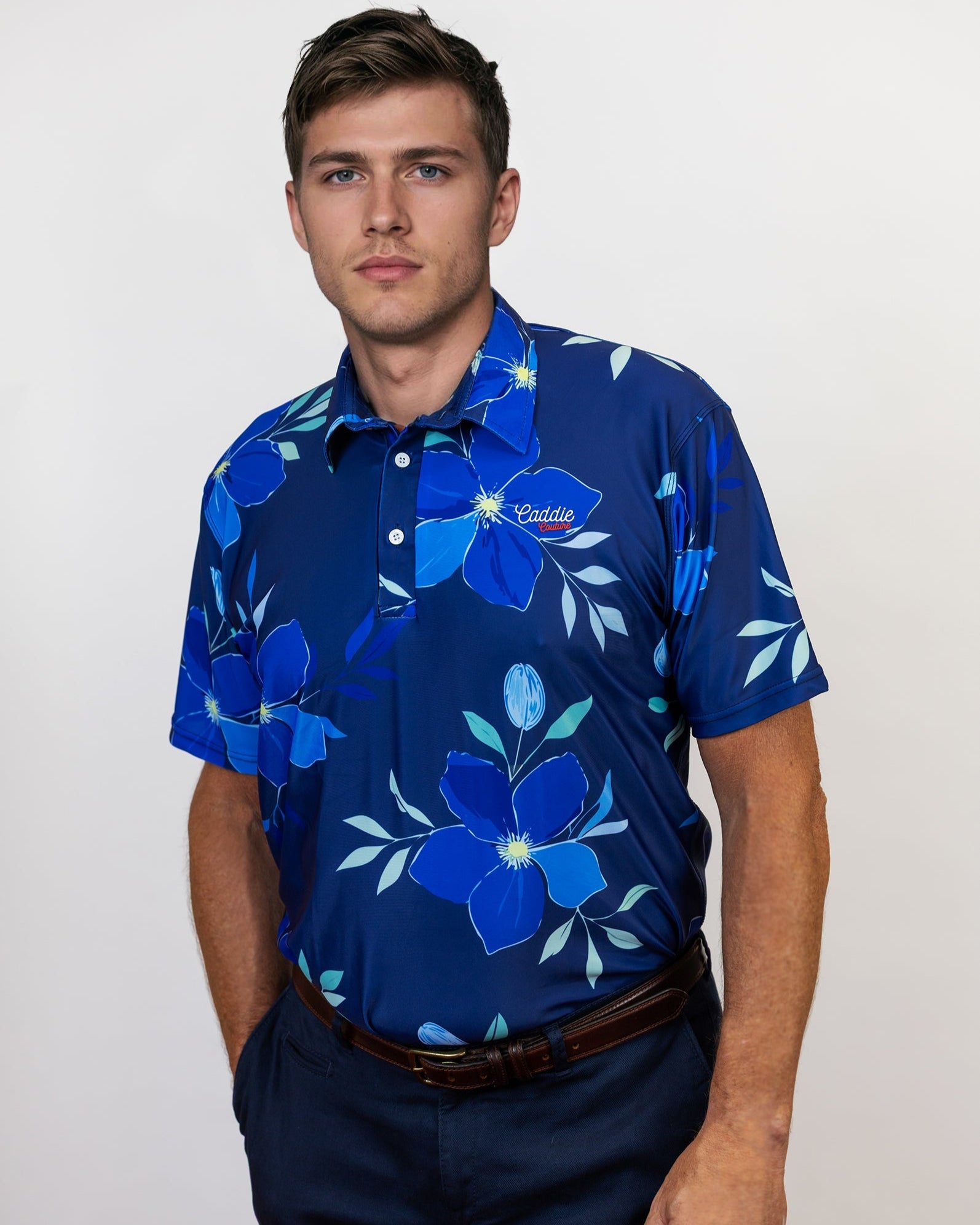 Man wearing a blue floral patterned golf shirt on a plain background