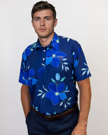 Man wearing a blue floral patterned golf shirt on a plain background
