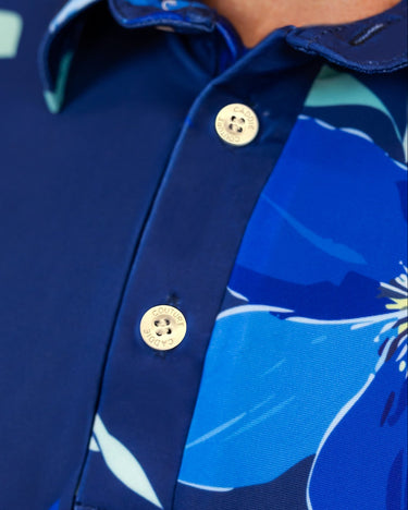 Close-up of a blue golf shirt with floral patterns and caddie couture buttons