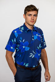 Man wearing a blue floral patterned golf shirt against a white background
