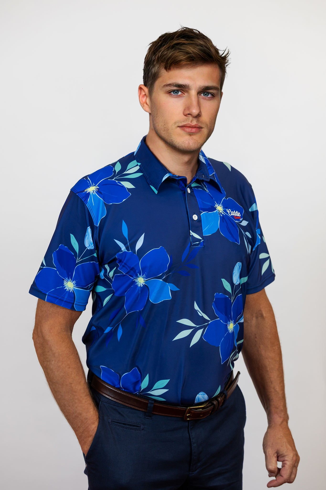 Man wearing a blue floral patterned golf shirt against a white background