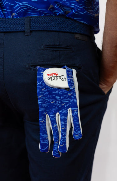 Blue and white golf glove with a brand logo on navy pants