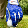 Blue golf glove on a golf ball with a blurred green background