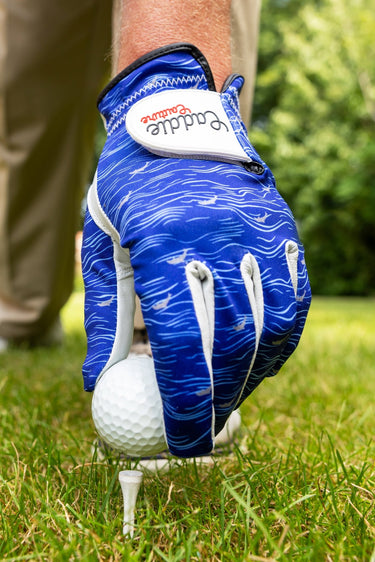 Blue golf glove on a golf ball with a blurred green background