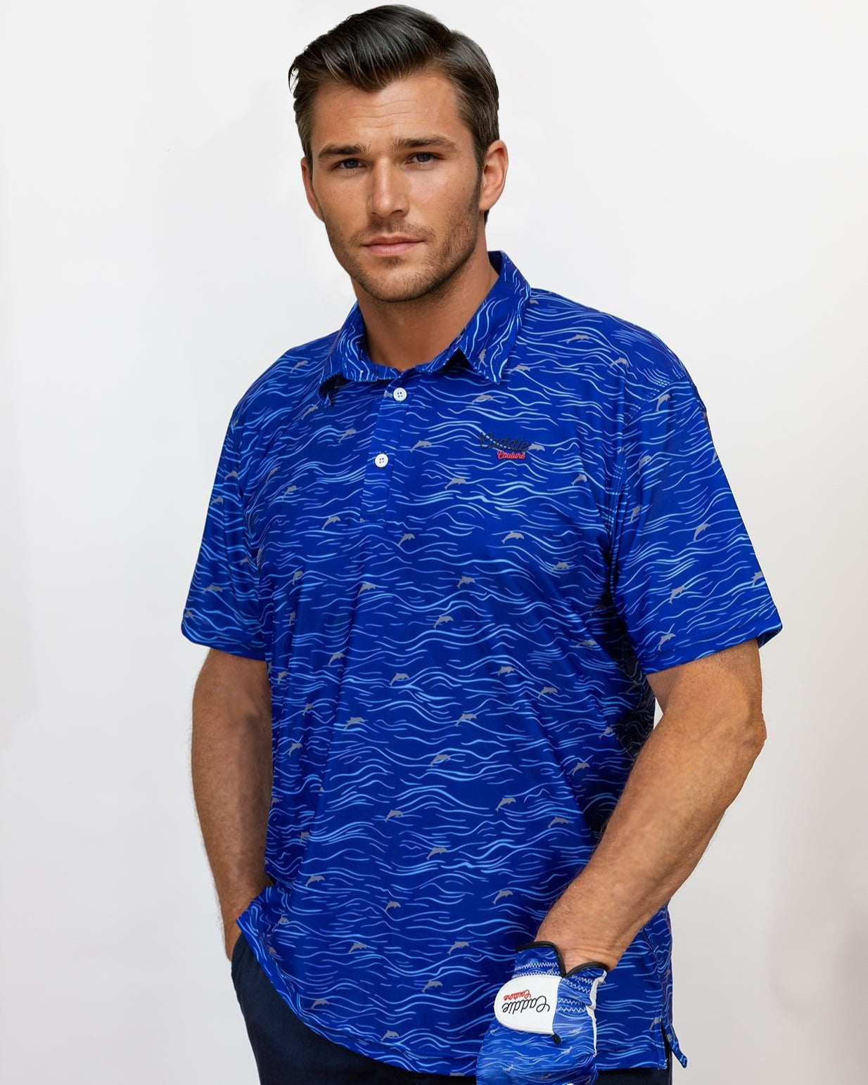 Man wearing a blue patterned golf polo shirt with a golf glove on a white background