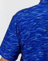 Blue golf shirt with dolphin pattern on a white background