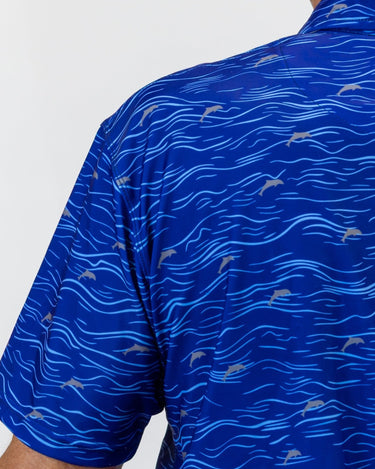 Blue golf shirt with dolphin pattern on a white background