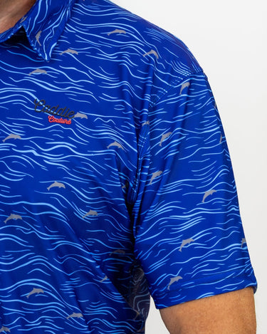 Blue patterned Golf shirt with a Caddie Couture logo on a grey background