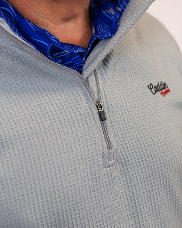 Man wearing golf quarter zip with blue wave pattern in neck