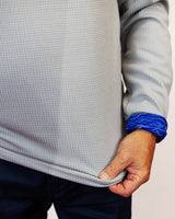 Man wearing golf quarter zip with blue wave pattern in neck. Close up of sleeve
