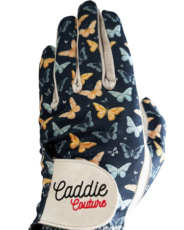 Glove with butterfly pattern and 'Caddie Couture' label on a white background