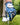 Golf glove with butterfly pattern holding a golf ball on grass