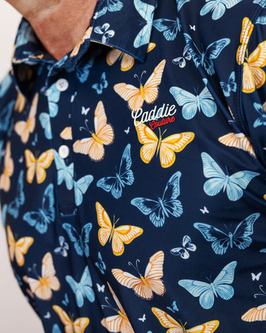 Navy Golf Polo with colorful butterfly pattern and 'Caddie Couture' branding.