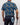 Person wearing a navy shirt with butterfly pattern, holding a golf club, on a plain background