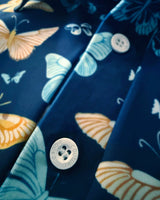 Close-up of a golf polo with butterfly pattern and button, featuring the brand 'Caddie Couture"