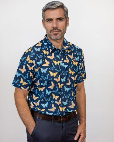 Male Model with hand in his pocket wearing a butterfly pattern golf polo