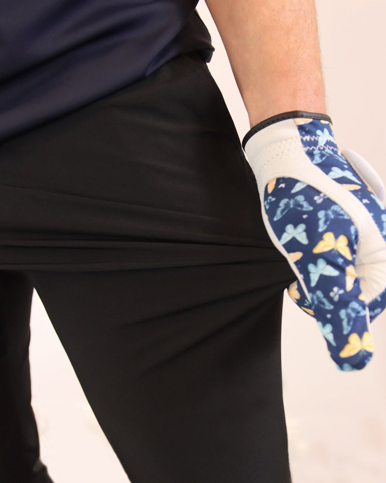 Person wearing a blue patterned glove on a plain background