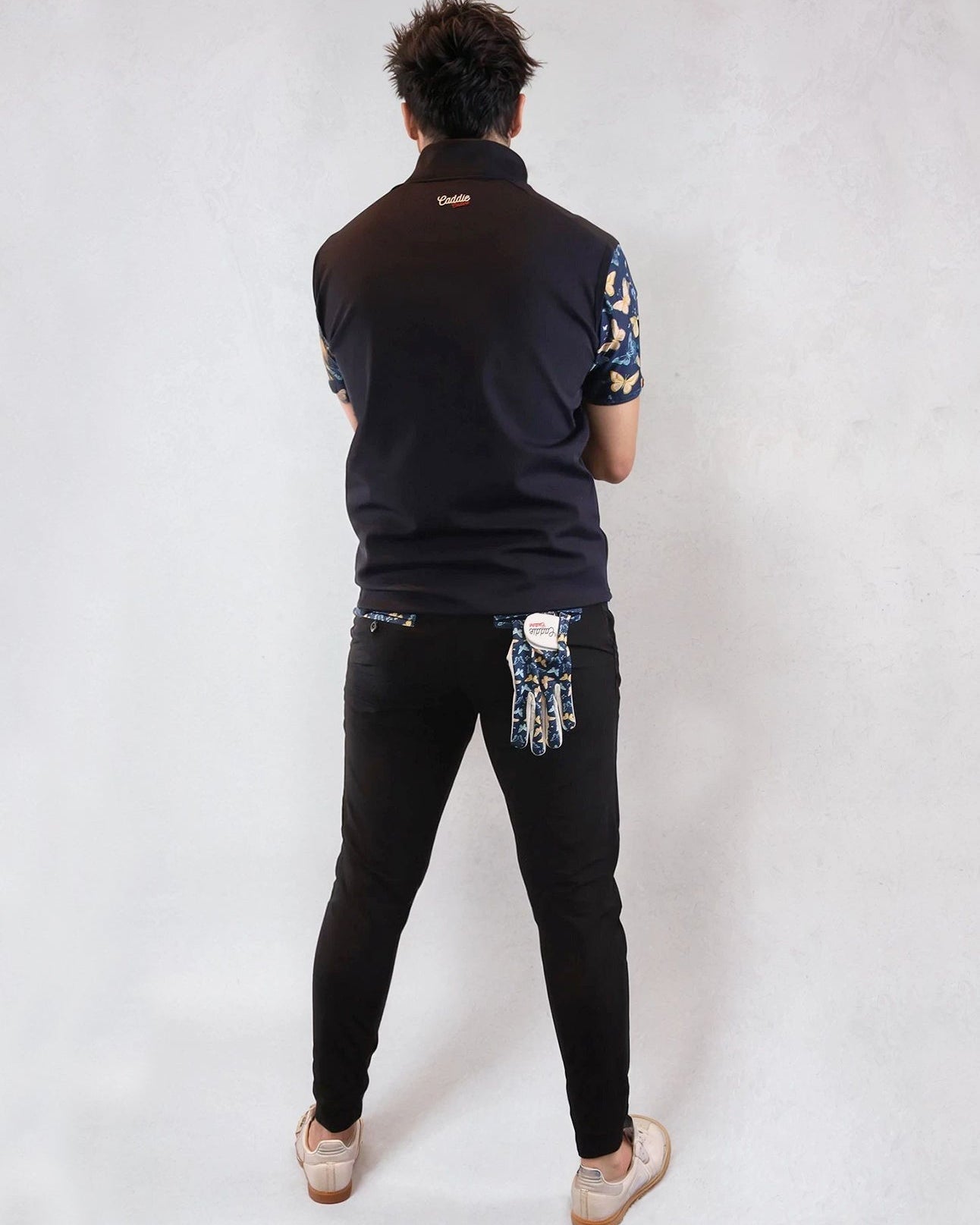 man with back to camera wearing black golf joggers