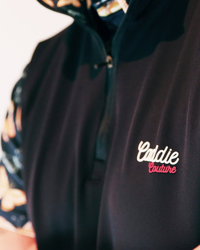 Navy Golf Vest with 'Caddie Couture' logo on a blurred background