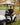 Man sitting in a golf cart on a golf course with autumn leaves and trees in the background