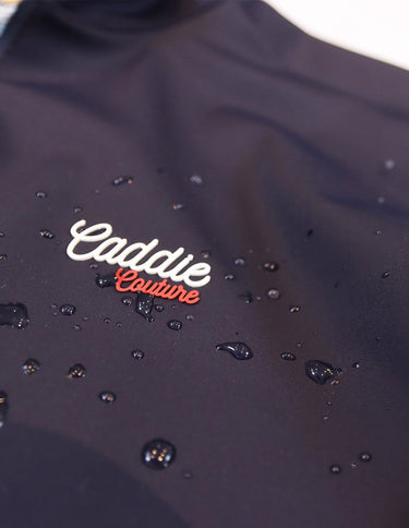 Navy Golf Vest with 'Caddie Couture' logo on a white background. with Droplets of water on
