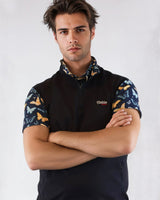 Man wearing a blue golf vest with butterfly pattern sleeves on a white background