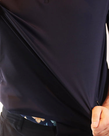 Person wearing a navy blue shirt with floral sleeves against a white background