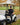 Man sitting in a golf cart on a golf course with autumn leaves and trees in the background
