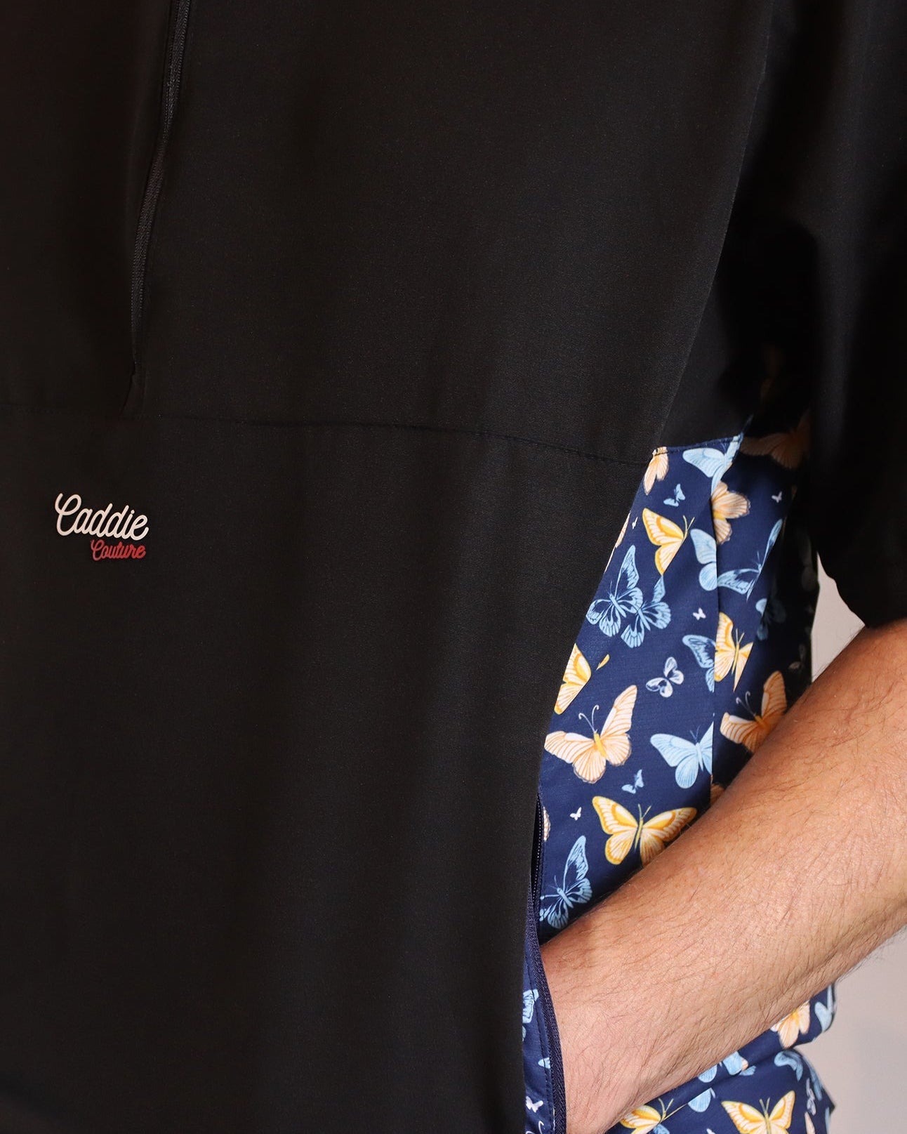 Black jacket with a butterfly patterned lining and 'Caddie' branding.