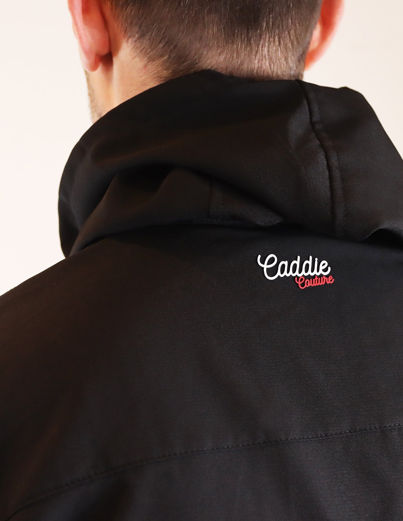 Black jacket with 'Caddie Couture' logo on a plain background