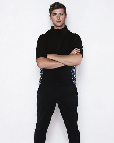 Man wearing a black windbreaker shirt with butterfly sides against a white background