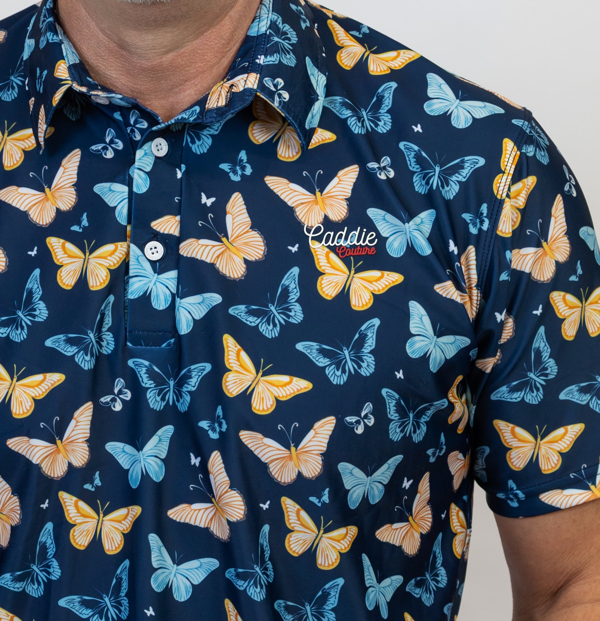 Navy blue Golf Polo with colourful butterfly pattern worn by a person
