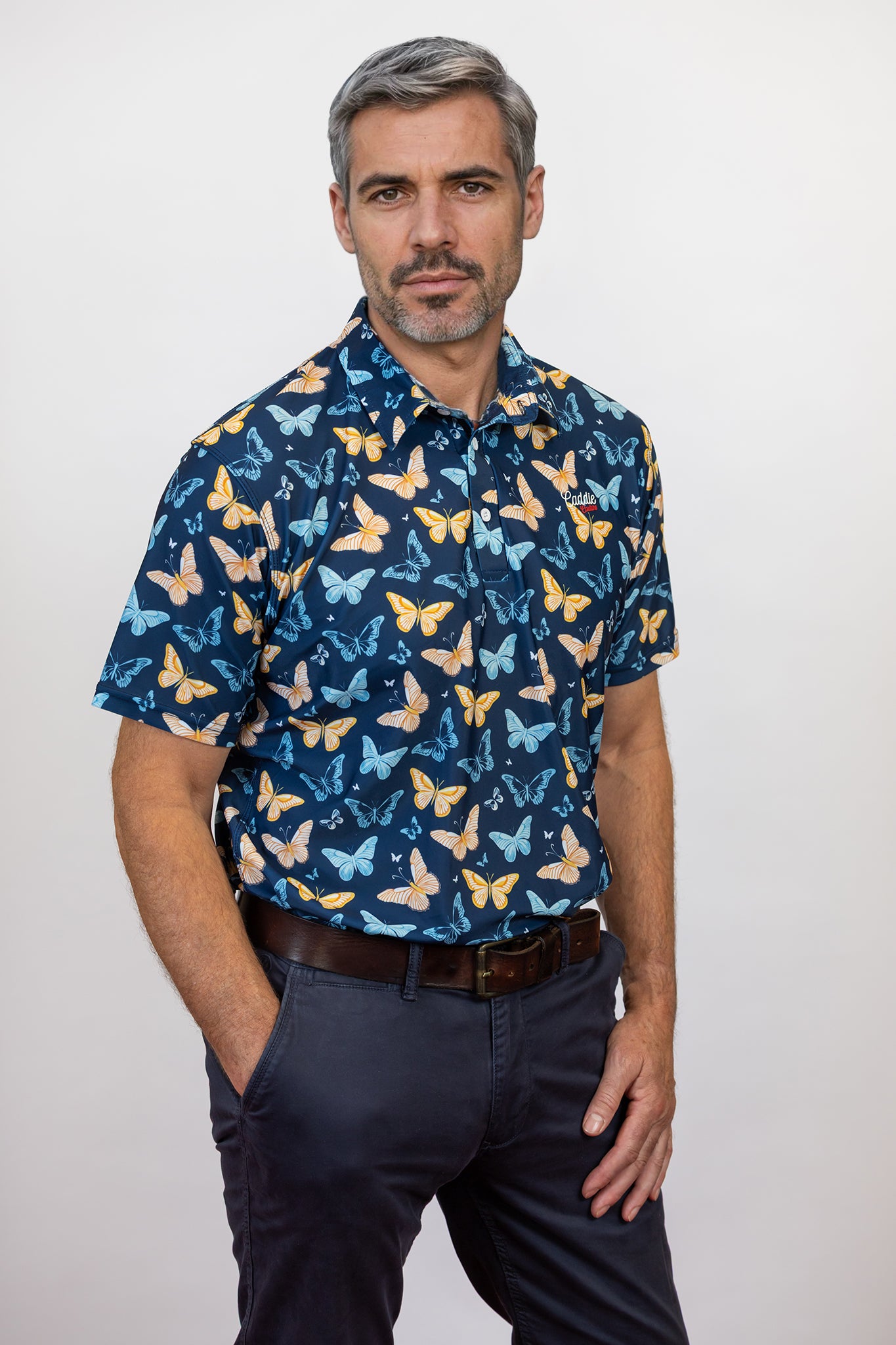 Male Model with hand in his pocket wearing a butterfly pattern golf polo