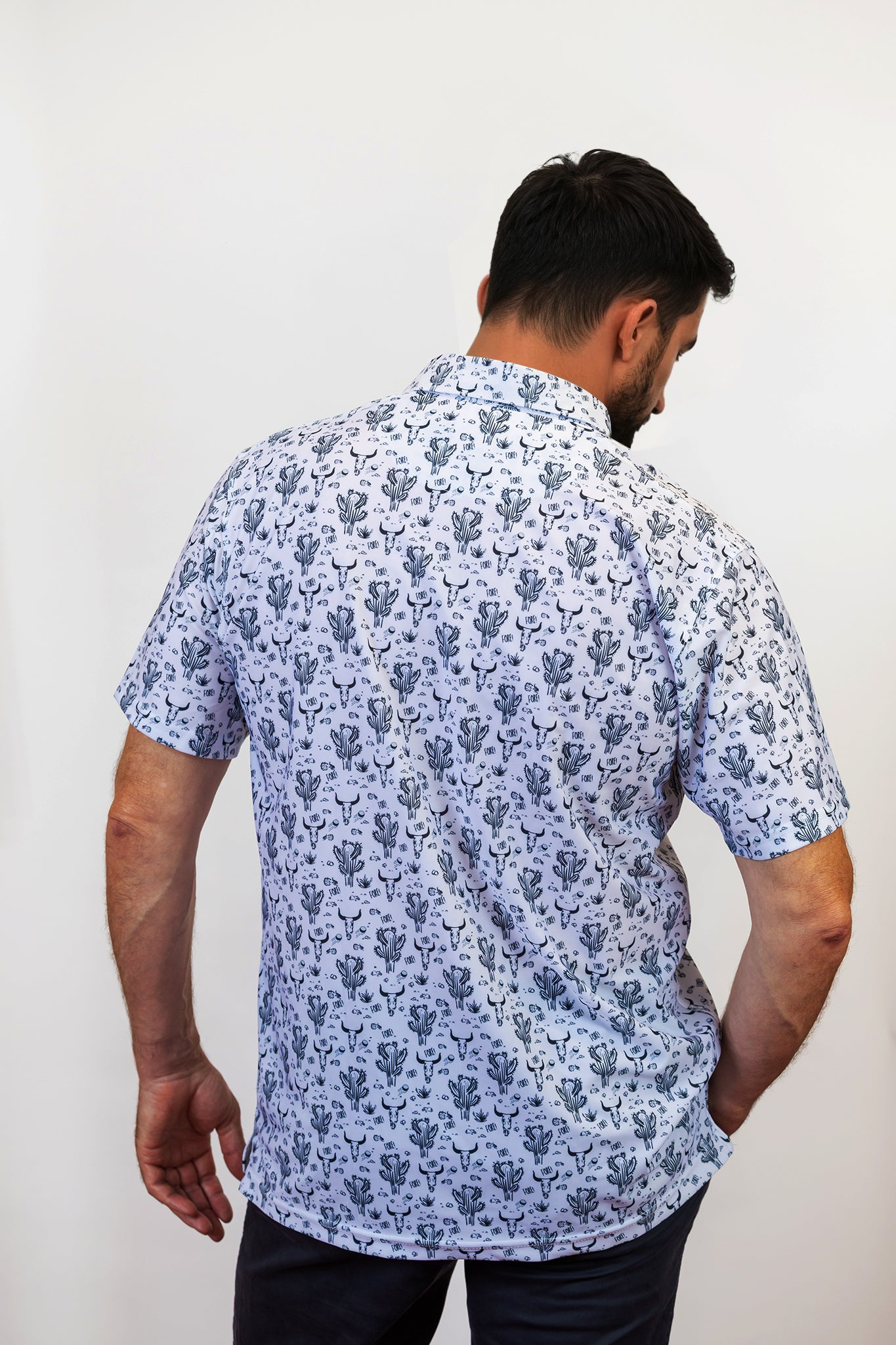 Man Wearing Cactus and Bull Golf Polo Untucked with back to the camera