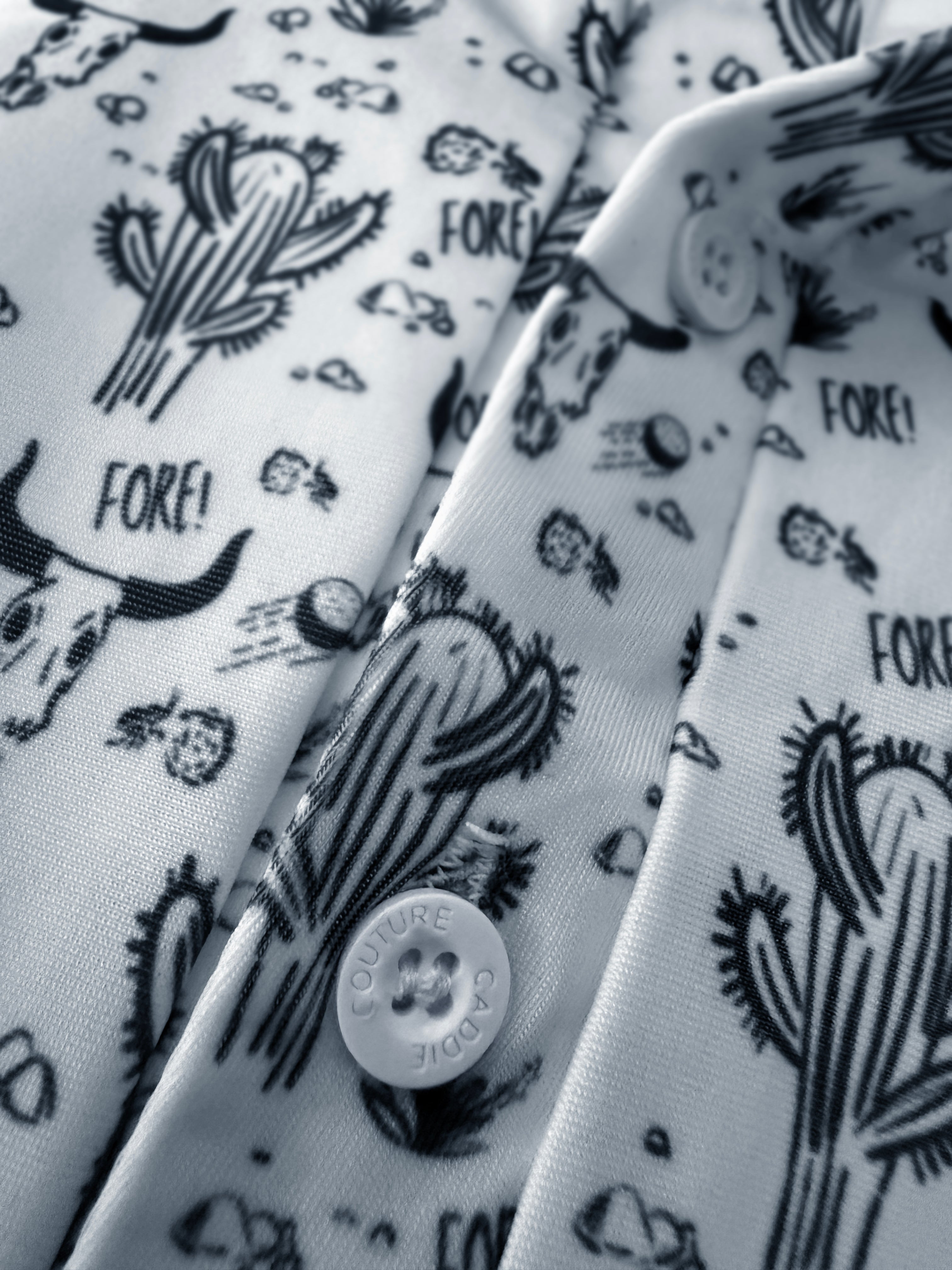 White shirt with black cactus and 'FORE!' pattern, featuring a caddie couture button.