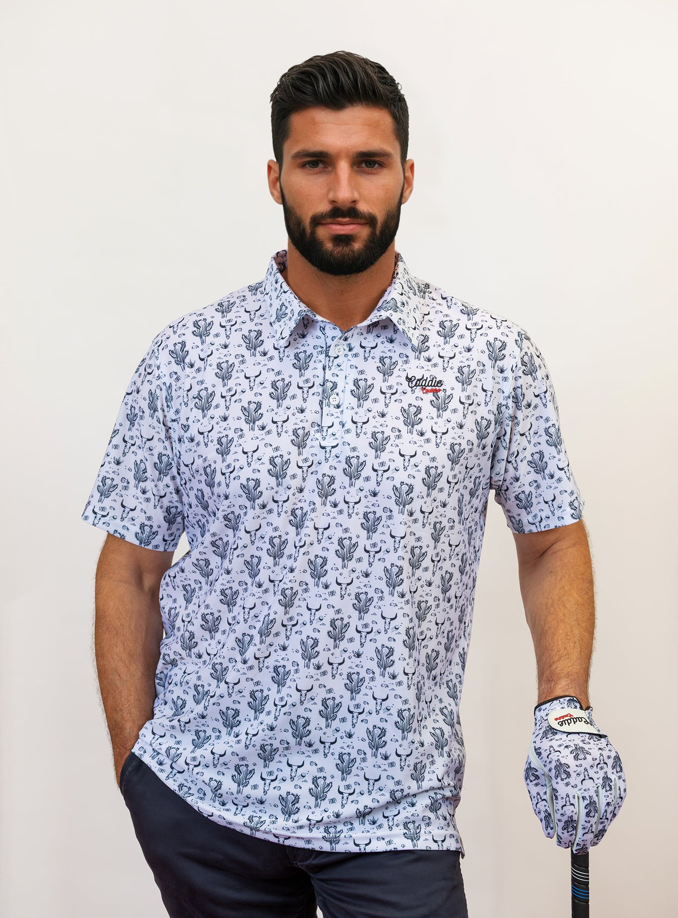 Man wearing a cactus and Bull head pattern golf shirt, holding a golf club.