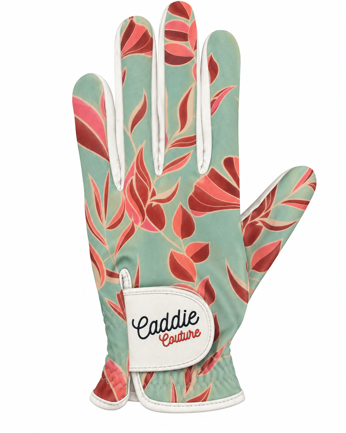 A single golf glove from Caddie Couture featuring a sage green base with a coral and pink leaf pattern, white trim, and a white hook-and-loop strap with the brand name.