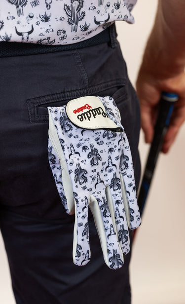 Golf glove with a pattern on a person's hand holding a golf club.
