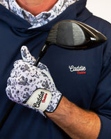 Person wearing a navy hoodie with 'Caddie' branding, holding a golf club with a matching glove.