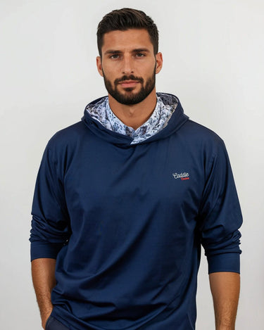 Man wearing a navy blue golf hoodie with a patterned lining on a white background