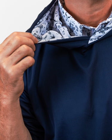 Navy blue golf hoodie with patterned lining being adjusted by a hand