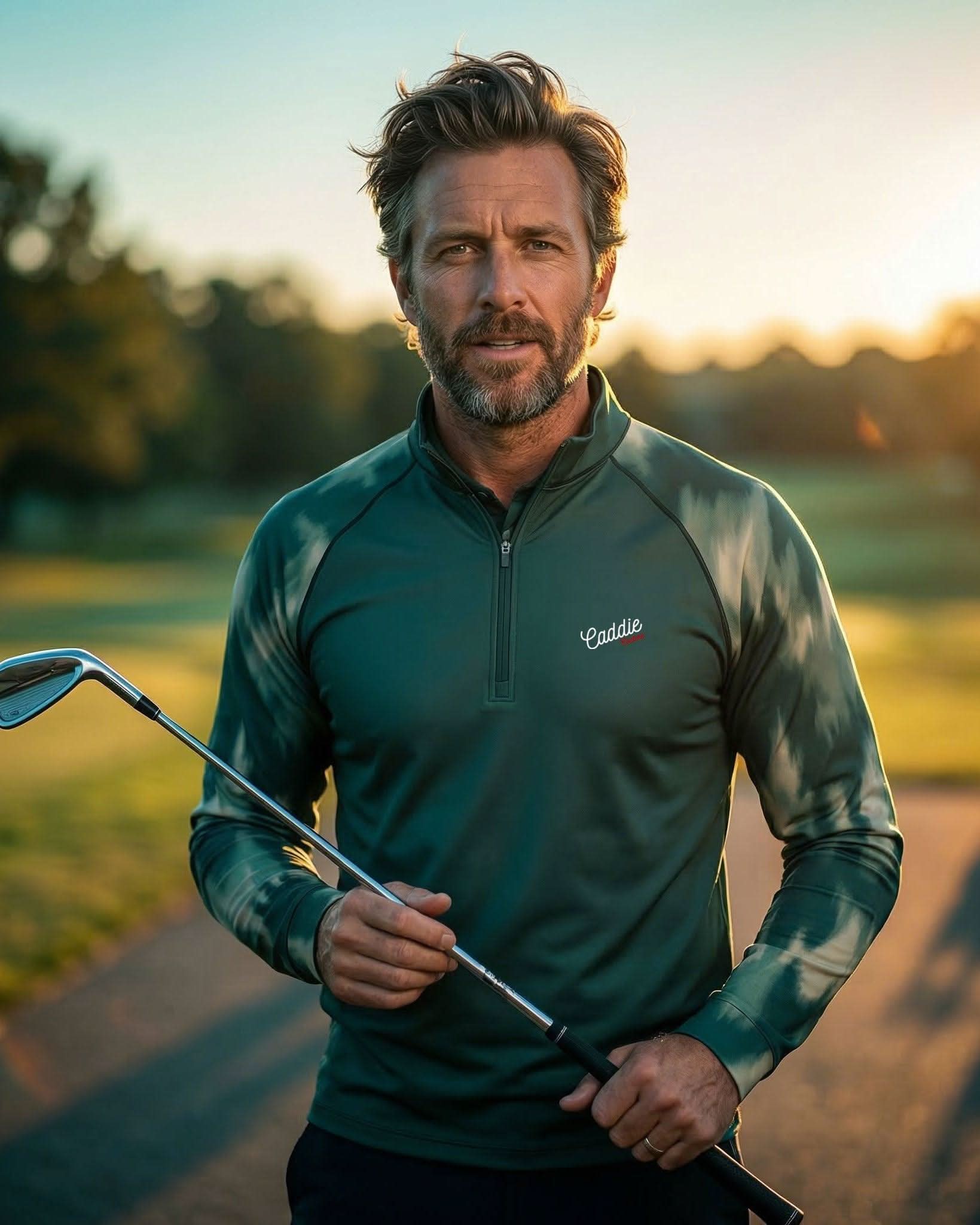 Man holding a golf club on a golf course with sunset in the background
