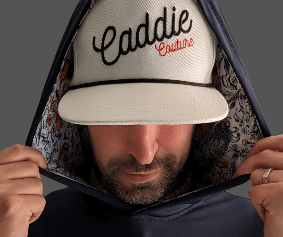 A male model wearing a navy blue hoodie with vintage floral print detailing on the hood.