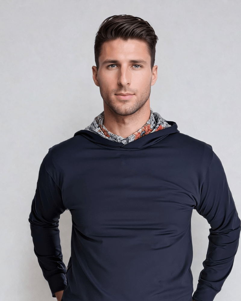 A male model wearing a navy blue hoodie with vintage floral print detailing on the hood.
