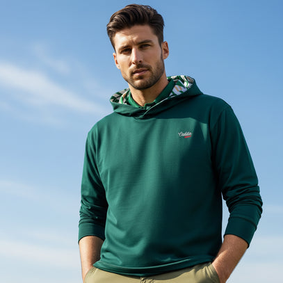 man wearing green golf hoodie with blue sky background
