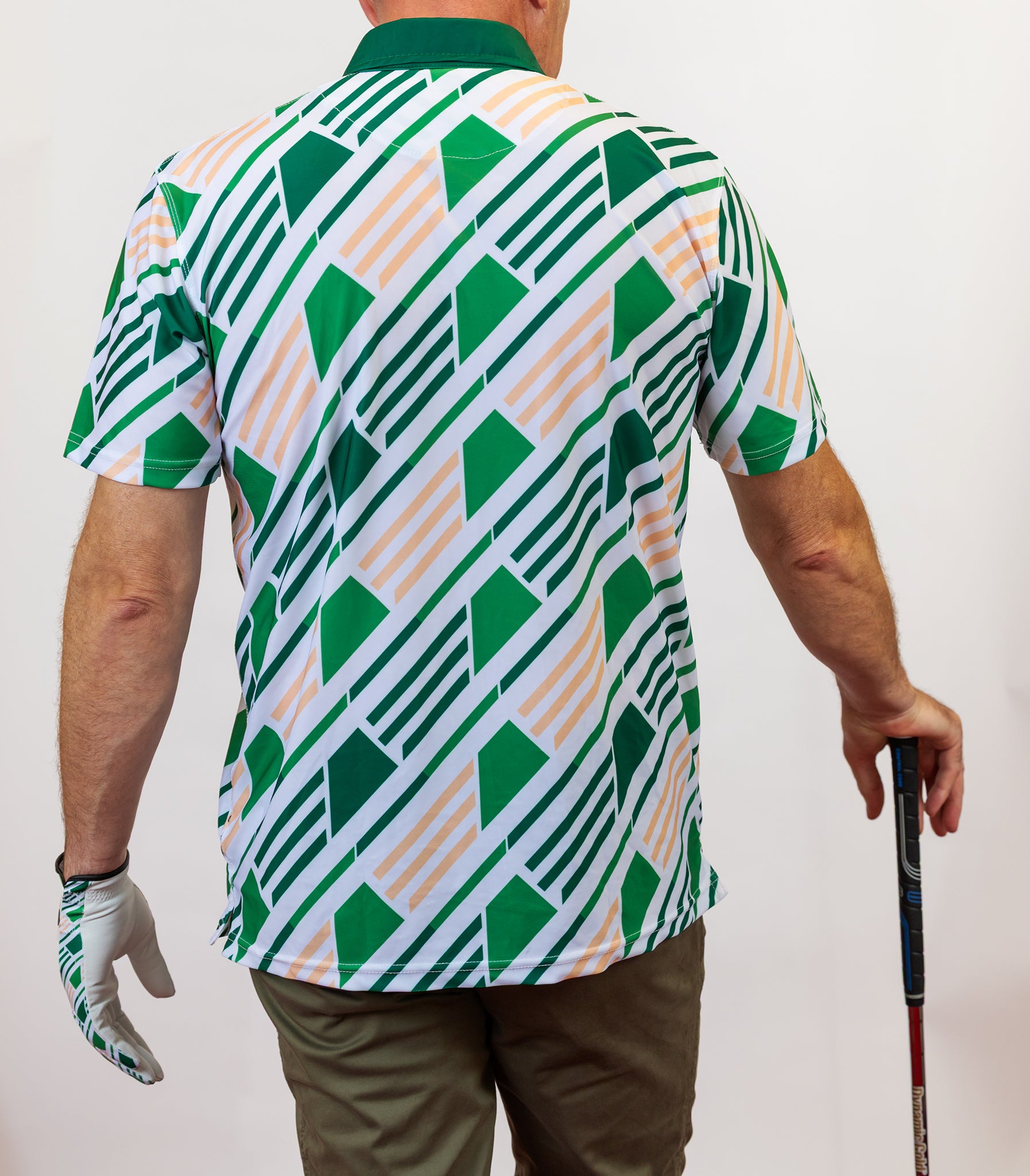 Person wearing a green and white patterned shirt holding a golf club.