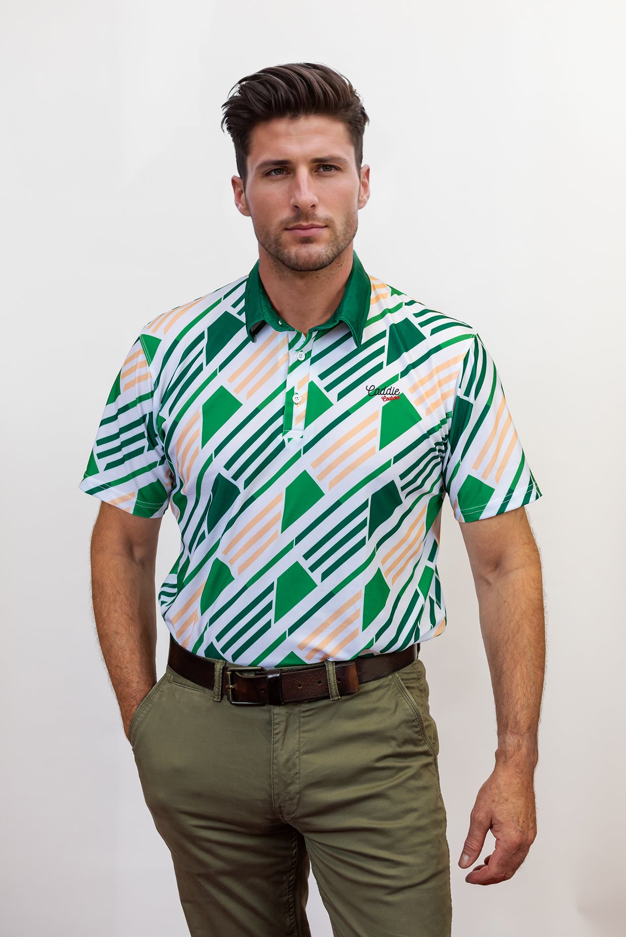 Man wearing a patterned golf shirt and green pants against a white background