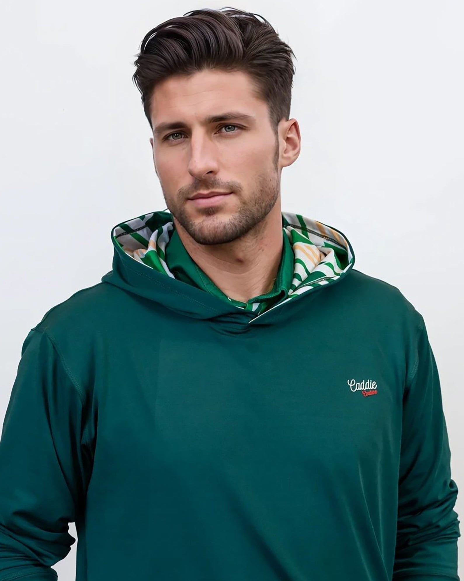 Man wearing a green golf hoodie with a brand logo on a white background