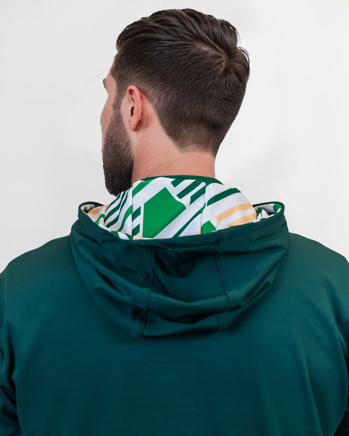 Person wearing a green golf hoodie with a patterned hood against a white background